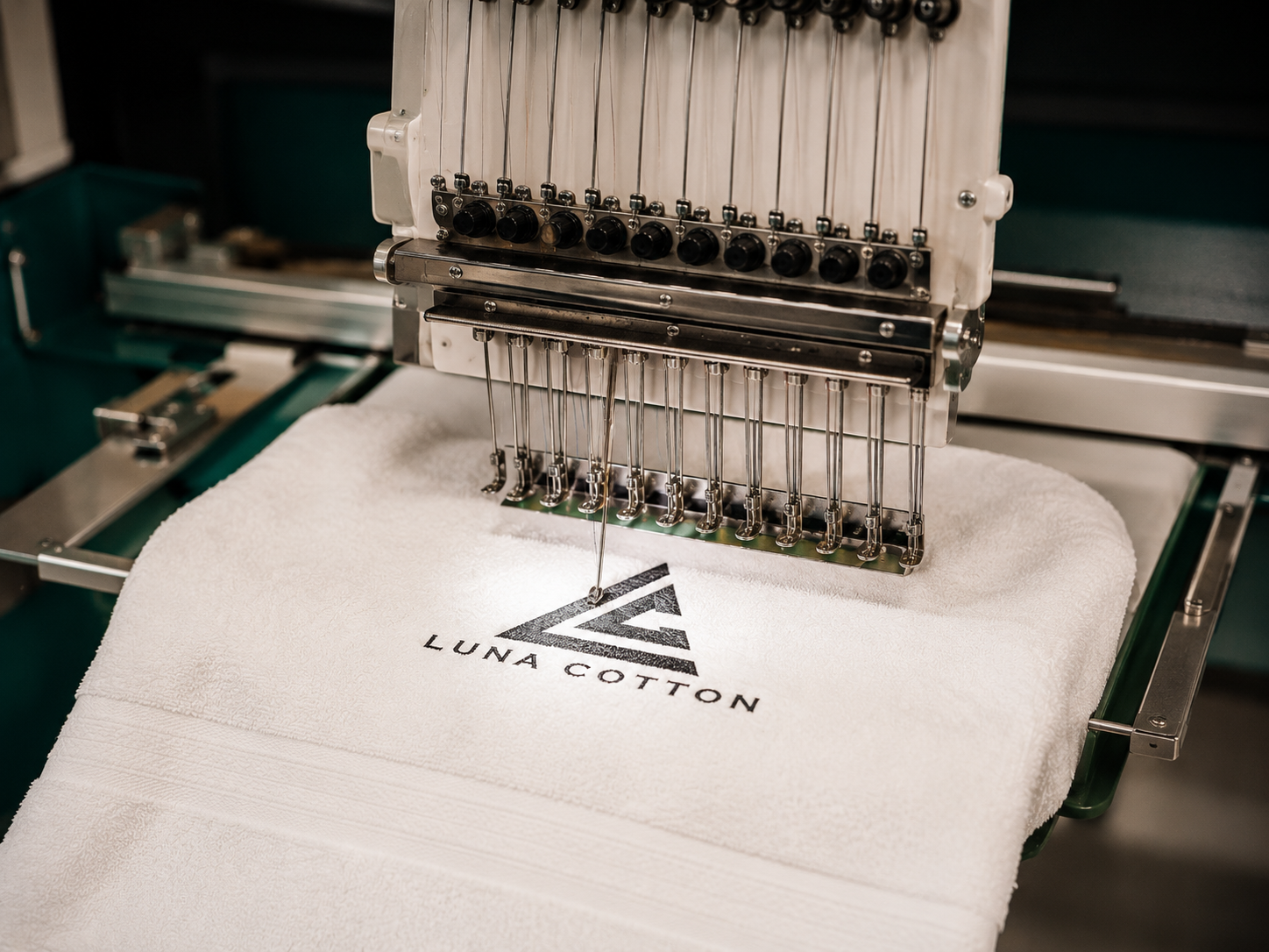 Luna Cotton logosunun beyaz havlu üzerine işlendiği nakış makinesi sahnesi